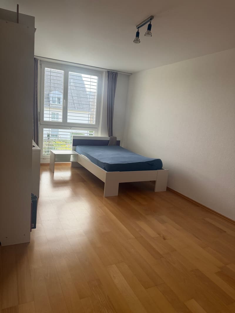 small bedroom with bed, white wardrobe, wooden floor