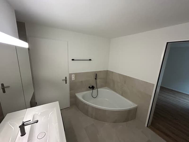 Bathroom with bathtub, sink, and mirror