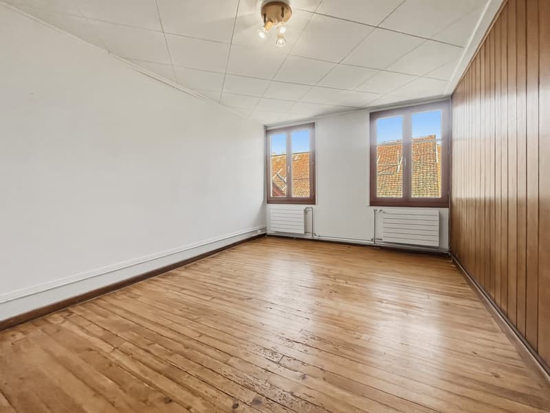 Empty room, wooden floor, white walls, large windows, ceiling lights, wooden panels