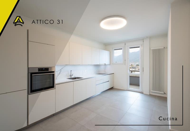 Modern kitchen with white cabinets, marble countertop, stainless steel sink, oven, and a ceiling light.