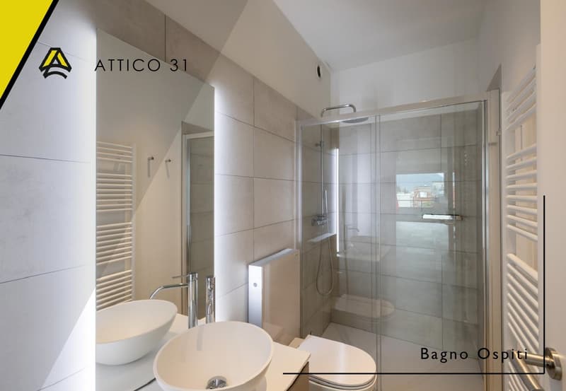 Modern bathroom with a glass shower enclosure, a white sink, and a toilet. The walls are tiled, and there is a radiator on the wall.