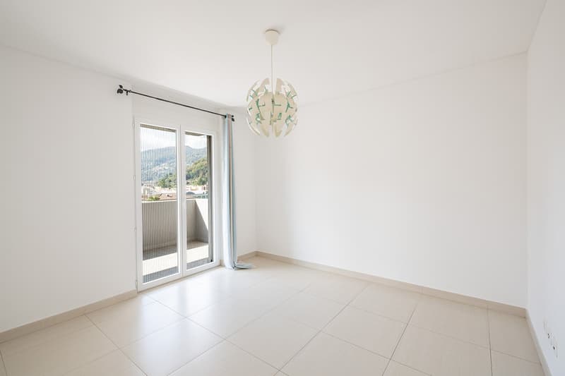 empty room, white walls, tiled floor, sliding glass door, balcony, chandelier