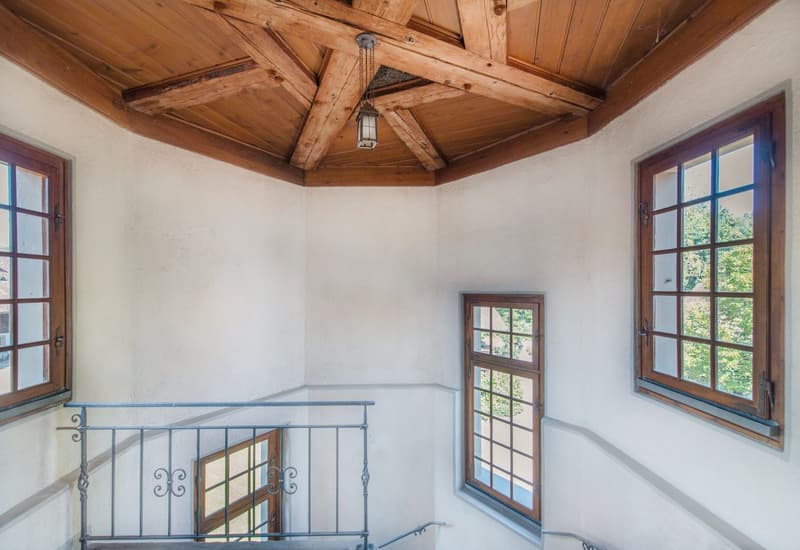 wooden ceiling, white walls, three windows, metal railing, hanging lamp