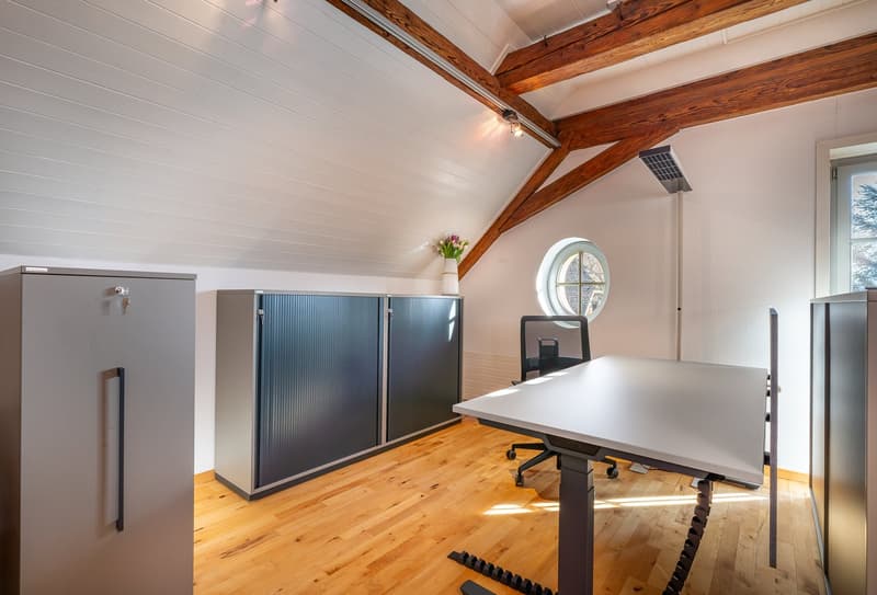 wooden floor, wooden beams, office desk, office chair, cabinets, round window, flower vase