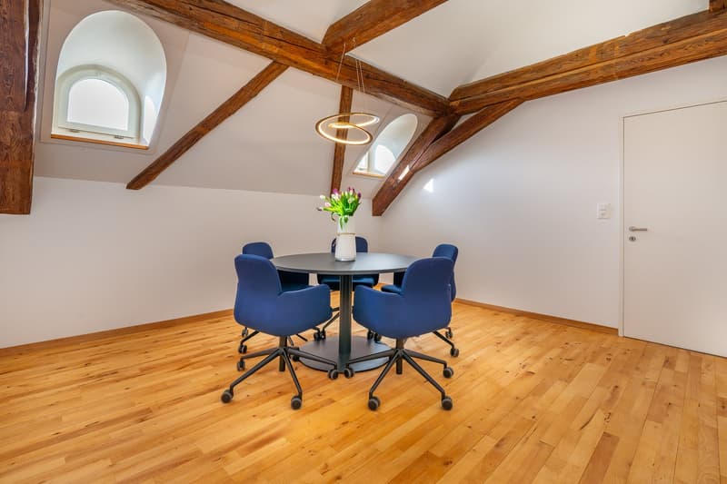 wooden floor, wooden beams, round table, blue chairs, white door, flower vase, windows