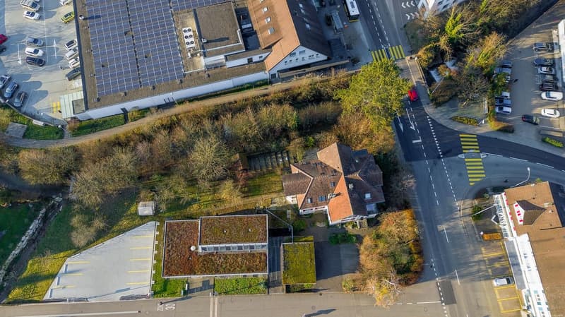 large house, solar panels, parking lot, trees, road, cars parked