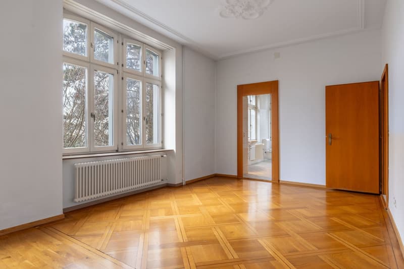 wooden floor, white walls, large windows, radiator under the window, entrance door