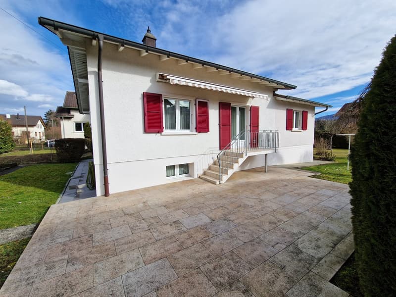 white house, red shutters, tiled driveway, stairs leading to entrance, garden, green grass