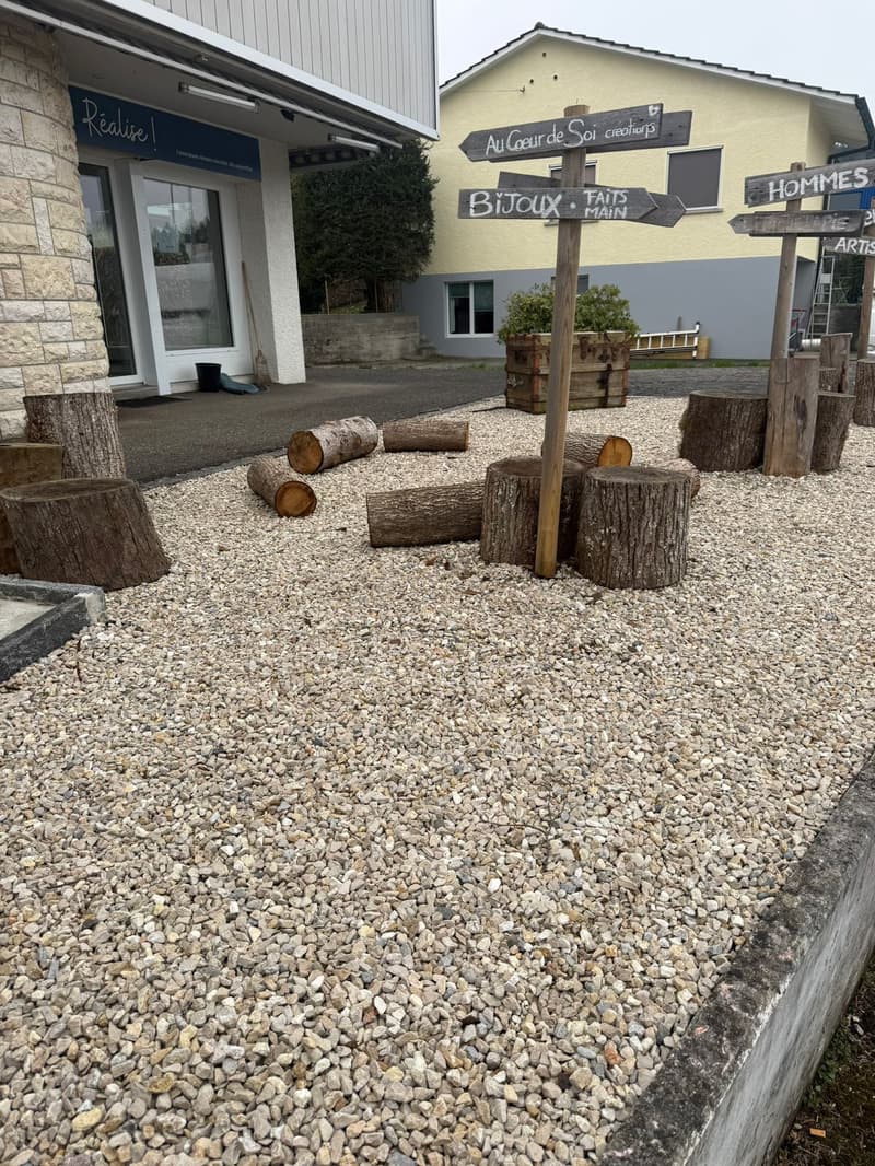 gravel ground, wooden posts, cut tree trunks, directional signs