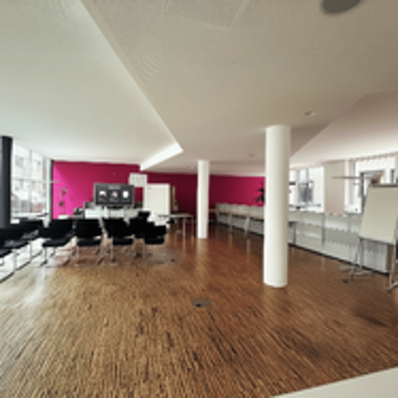 Empty room with wooden floor, pink walls, white ceiling, chairs, TV, whiteboard