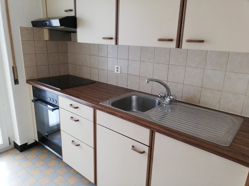 kitchen with stove, oven, sink, cabinets, tiled backsplash, countertop