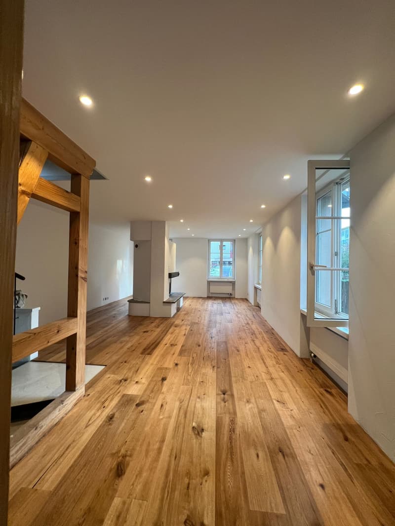 wooden floor, white walls, fireplace, radiators, large windows