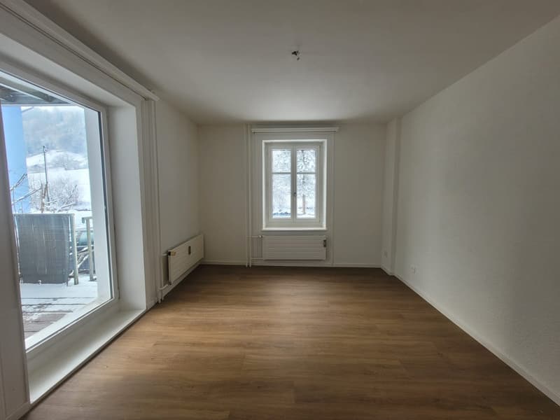 Empty room, wooden floor, two windows, large balcony, white walls