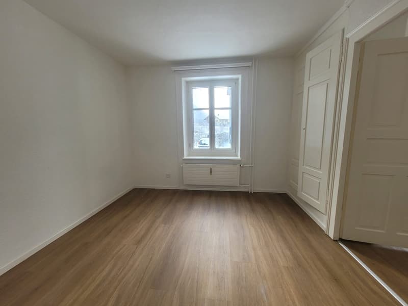empty room, white walls, wooden floor, window with a white frame