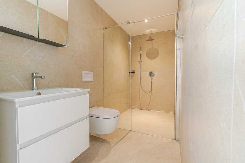 Badezimmer mit Regendusche und Einbaumöbel