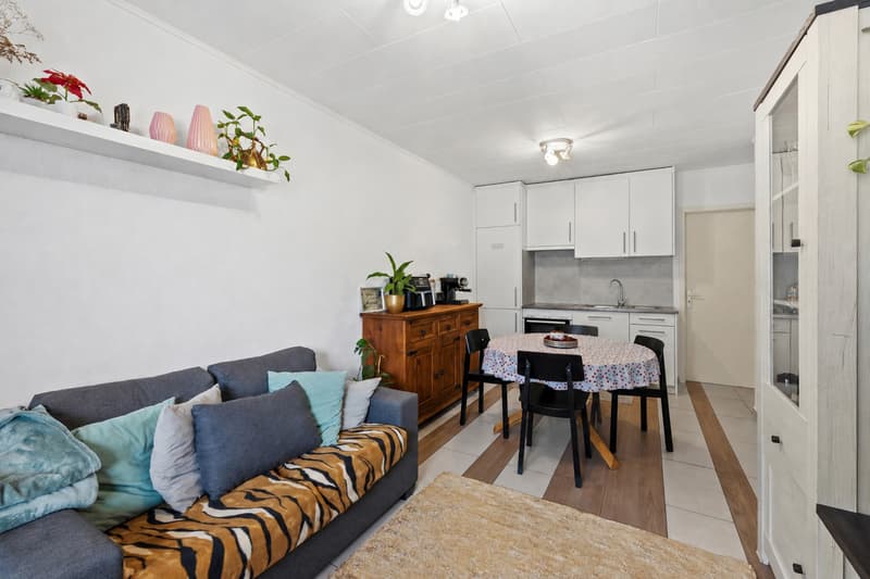 Espace séjour et cuisine ouverte / a small room with a couch, table, and kitchen