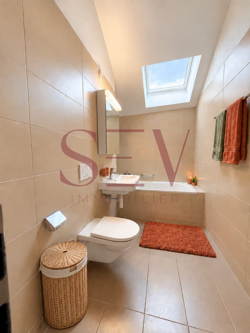 Salle de bains avec baignoire et lumière naturelle