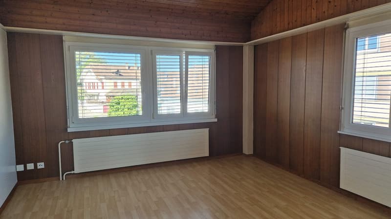 empty room with wooden floor, double windows, heating systems, and power outlets