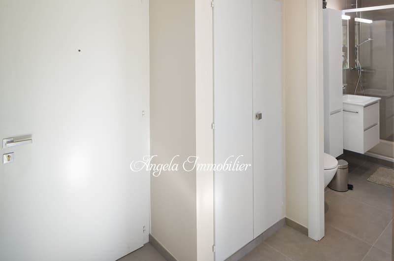 White walls, tiled floor, white toilet, sink, glass shower, white cabinet