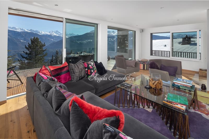 large windows, balcony, glass table, couch, pillows, carpet, view of mountains