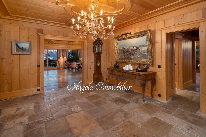 wooden walls, chandelier, wooden table, painting, grandfather clock, tiled floor
