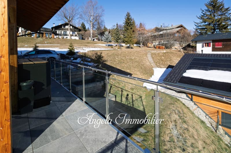 2 story wooden house, balcony, snowy landscape, trees, parking space