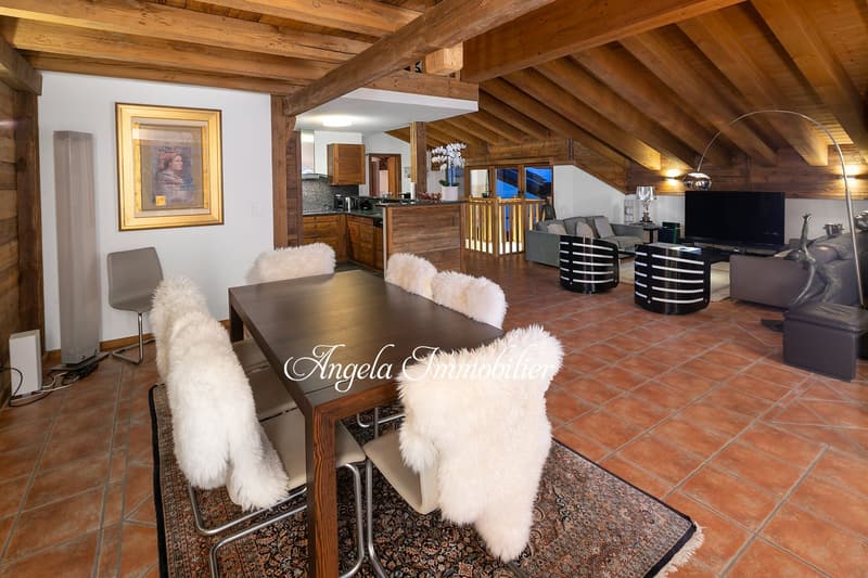 open plan living room and dining area, wooden beams, wooden floor, dining table with chairs, sofa, armchairs, TV, kitchen, picture frame, floor lamp