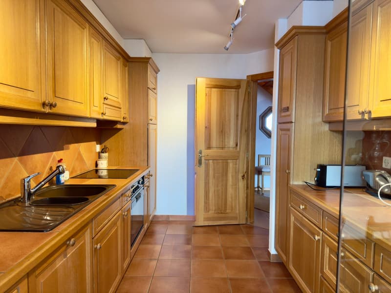 kitchen area, double sink, dishwasher, gas stove, oven, toaster, wooden cabinets, tiled floor