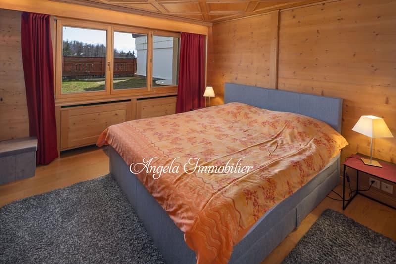 Large double bed, wooden paneling, large window with view, carpeted floor, two lamps