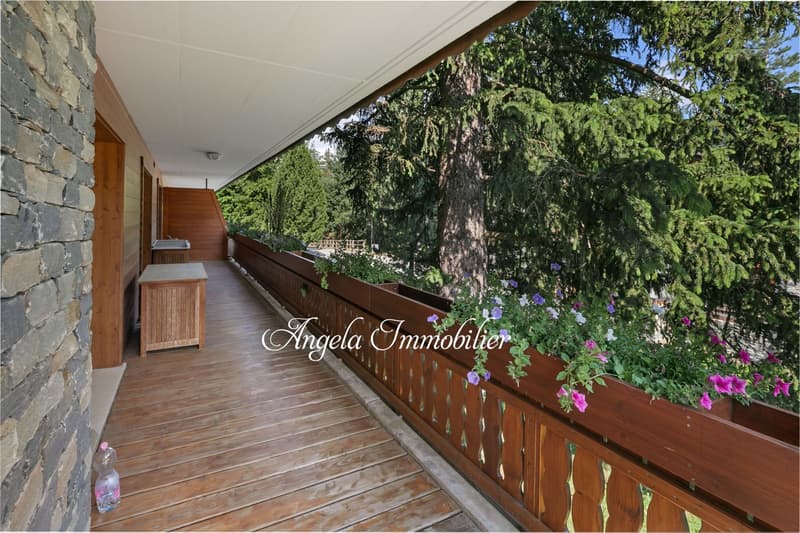 wooden floor, wooden railing, stone wall, wooden storage box, flowers in planters