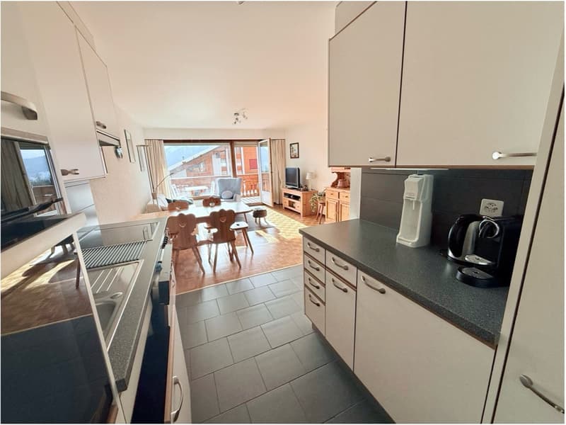 modern kitchen with dining area, large windows, wooden floor, white cabinets, granite countertops, appliances