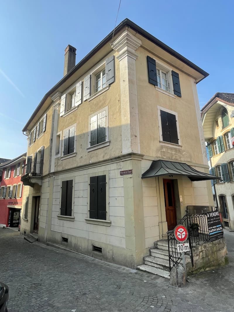Three story house, beige exterior, white shutters, steps to entrance, chimney