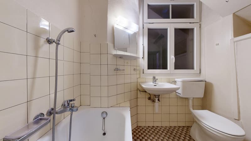 white tiled walls and floor, bathtub, shower, sink, toilet, mirror
