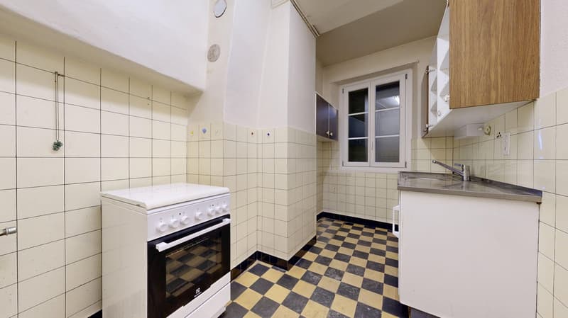 white tiles, black and yellow checkered floor, white stove, sink, small window