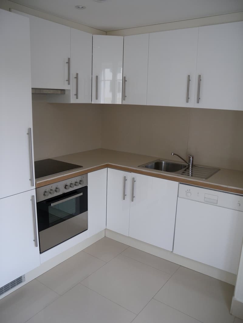 modern kitchen with white cabinets, tiled floor, stainless steel appliances, sink with faucet, dishwasher