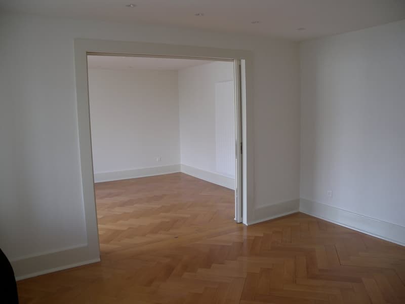 empty room, wooden parquet floor, white walls, open door
