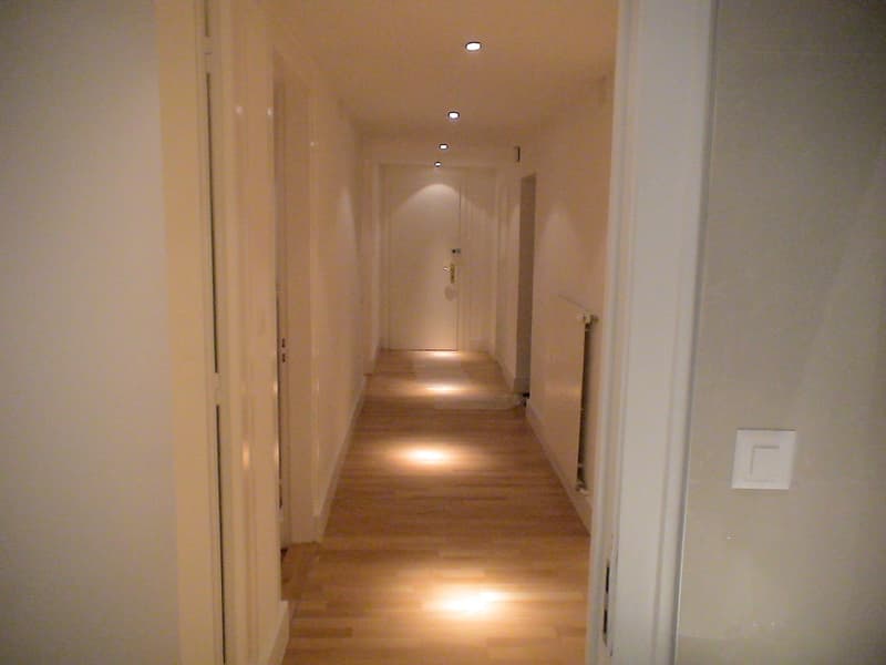 long hallway, wooden floor, white walls, recessed lighting