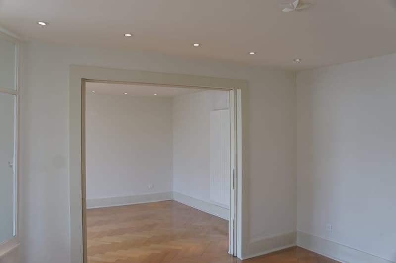 empty room, white walls, wooden floor, white ceiling, two doors