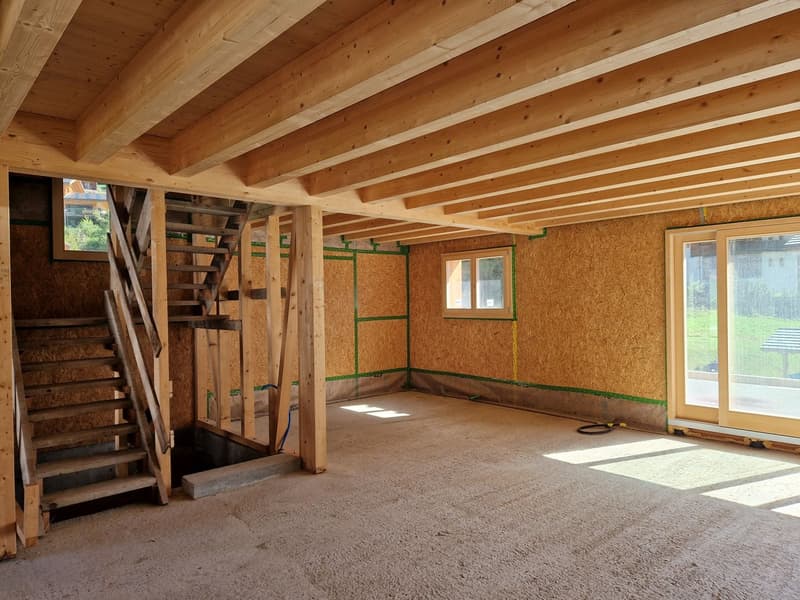 wooden beam ceiling, unfinished walls, wooden staircase, windows