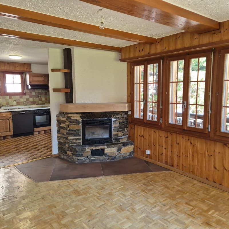 large stone fireplace, wood paneled walls, large windows