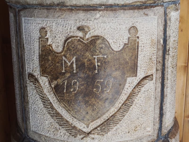 Fireplace with a shield design, initials MT, and the year 1959