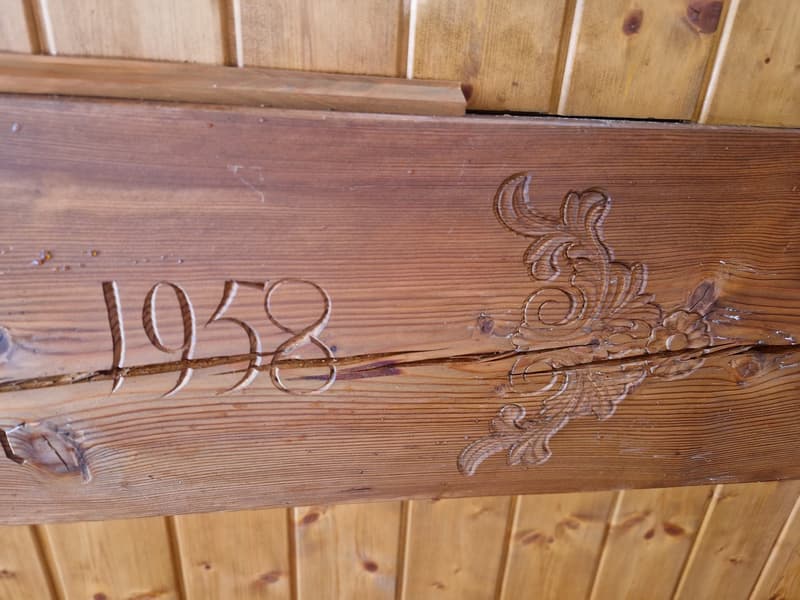 Wooden beam with the year 1958 carved into it, floral design