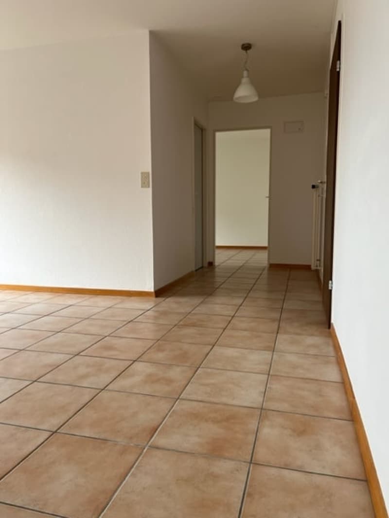 Empty room with tiled floor and white walls