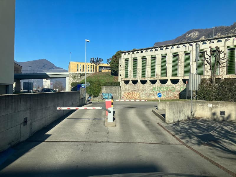 parking area in front of the building, concrete barriers, metal bollards, concrete walls, street lights