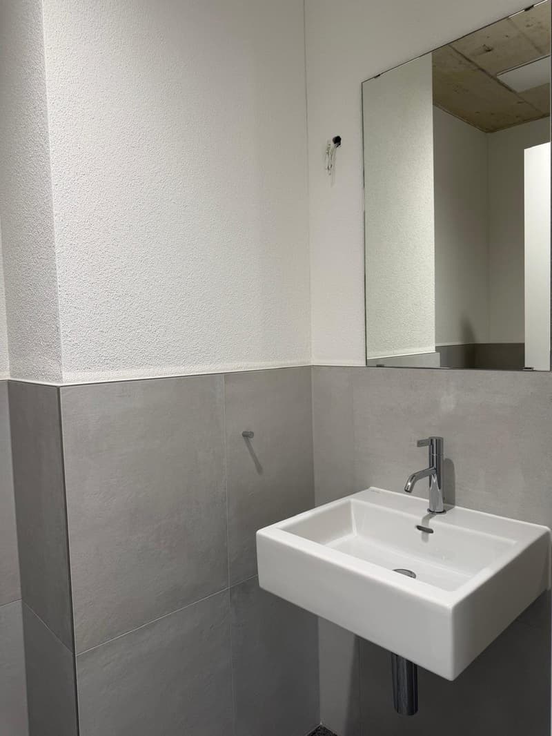 Bathroom with white walls and tiled floor, a modern sink, a mirror, and silver faucet.