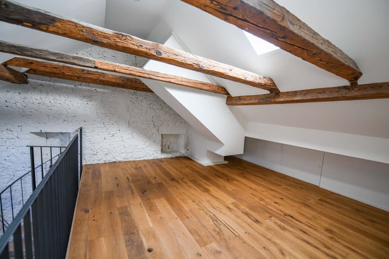 room with wooden beams, white walls, wooden floor, staircase