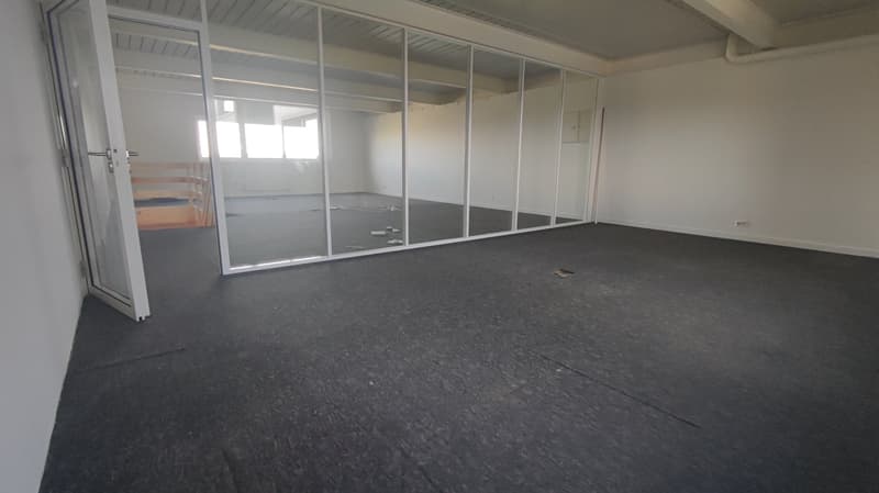 Empty room with glass walls, black floor, white walls, wooden bunk bed, windows