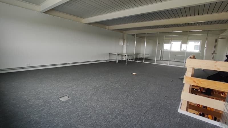 empty room, white walls, gray floor, two tables, glass walls, door