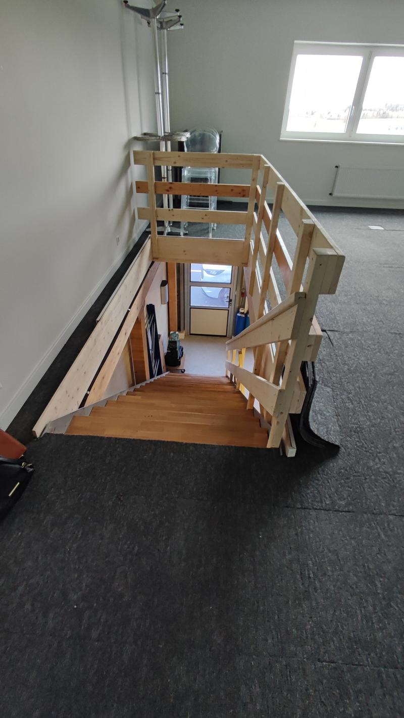 wooden staircase, wooden handrail, black carpet, white walls, glass door