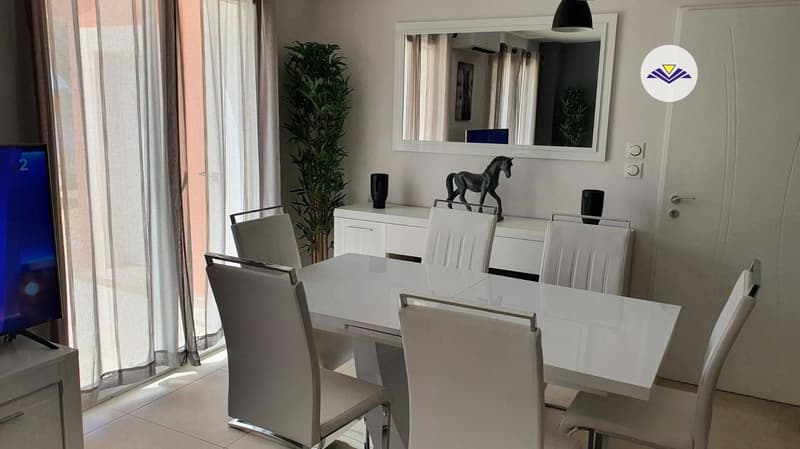 Spacious dining area with large windows, white table and chairs, built-in cabinets, decorative plant, and a black horse figurine on the cabinet.